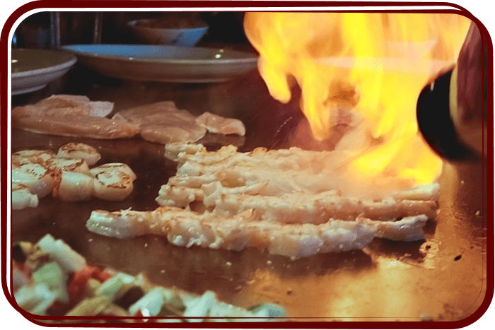 chef making shrimp and scallops on grill